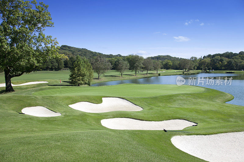 Sand traps and water hazard on pristine golf course